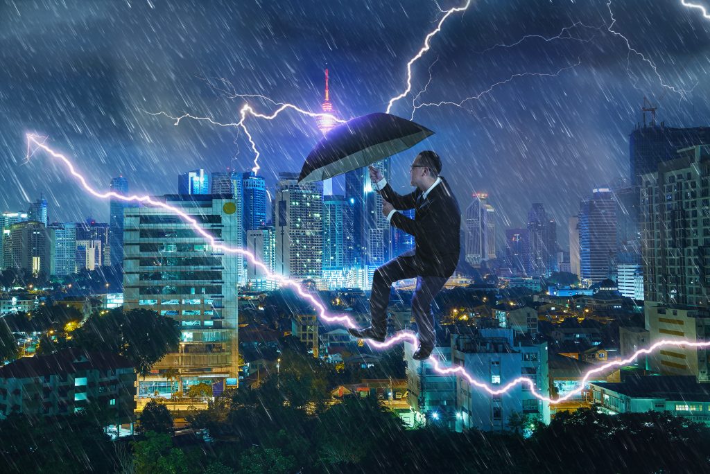 graphicstock young businessman umbrella against thunderstorm overcoming challenges crisis concept